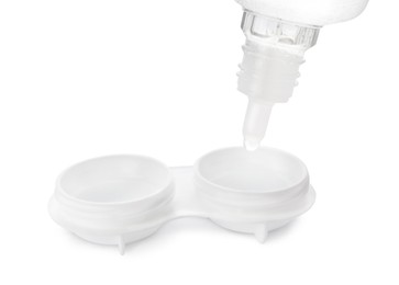 Photo of Dripping solution into case with contact lenses on white background