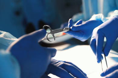 Professional surgeons performing operation in clinic, closeup