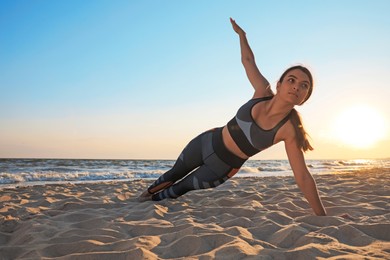 Young girl with slim body doing yoga on beach