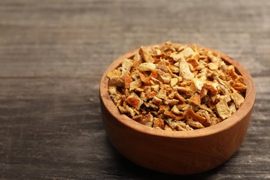 Photo of Bowl of dried orange zest seasoning on wooden table. Space for text