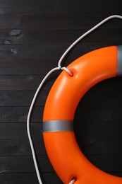 Orange lifebuoy on dark wooden background. Rescue equipment