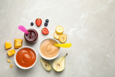 Healthy baby food and ingredients on grey table, flat lay. Space for text