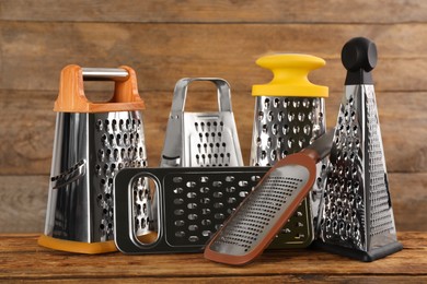 Different stainless steel graters on wooden table