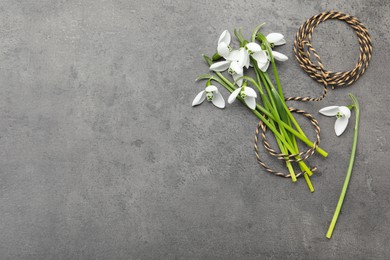 Beautiful snowdrops and twine on grey table, flat lay. Space for text