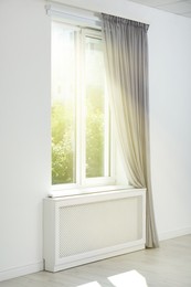 Bright sun shining through window with stylish curtain