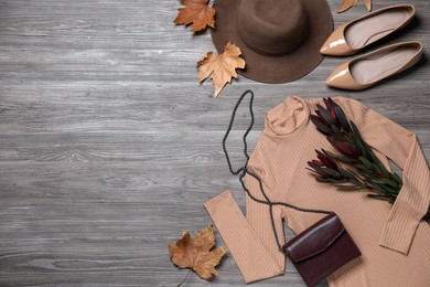 Fall fashion. Layout of women's outfit on wooden background, top view. Space for text