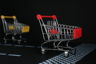Photo of Competition concept. Shopping carts racing towards finish line