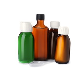 Photo of Bottles of syrups with plastic spoon on white background. Cough and cold medicine