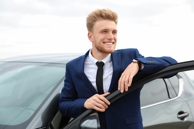 Photo of Young successful man near modern car outdoors