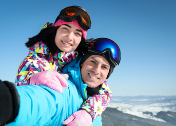 Photo of Young couple taking selfie in mountains. Winter vacation