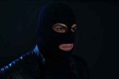 Photo of Man wearing knitted balaclava on black background