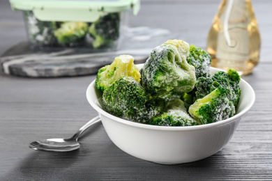 Frozen broccoli on light grey wooden table, closeup. Vegetable preservation