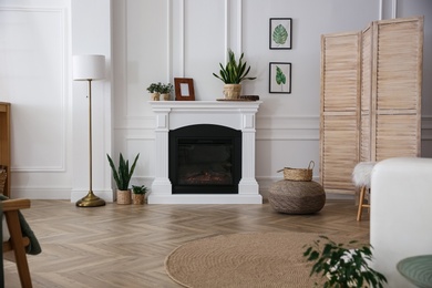 Elegant artificial fireplace in room. Interior design