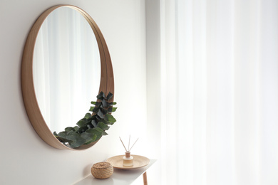Round mirror with wooden frame in light room