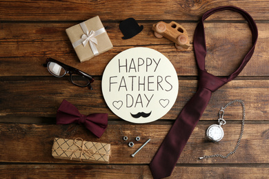 Flat lay composition of greeting card HAPPY FATHER'S DAY on wooden background