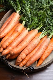 Photo of Many tasty fresh carrots on wooden table