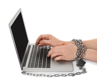 Photo of Woman with chained hands typing on laptop against white background, closeup. Internet addiction