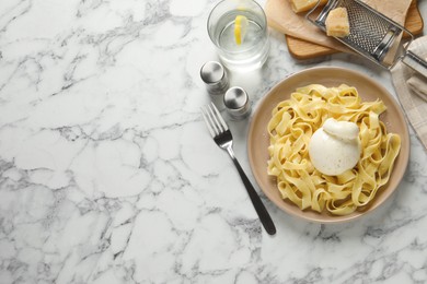 Delicious pasta with burrata cheese served on white marble table, flat lay. Space for text