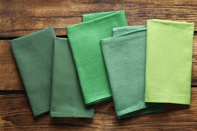 Different kitchen napkins on wooden table, flat lay