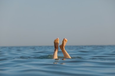 Photo of Drowning woman's legs sticking out of sea
