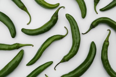 Photo of Many green hot chili peppers on white background, flat lay