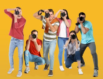 Group of professional photographers with cameras on orange background