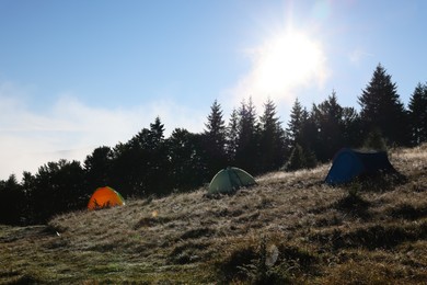 Picturesque mountain landscape with camping tents in morning
