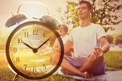 Time to do morning exercises. Double exposure of people practicing yoga in park and alarm clock