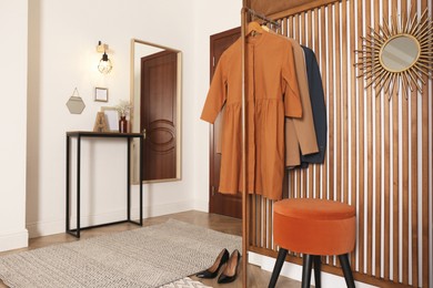 Modern hallway interior with stylish furniture and clothes rack