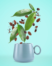 Cocoa beans and leaves falling into cup on turquoise background 