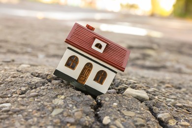 House model in cracked asphalt. Earthquake disaster