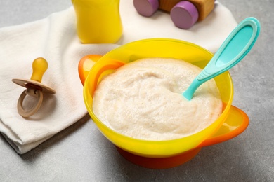 Healthy baby food in bowl on grey table