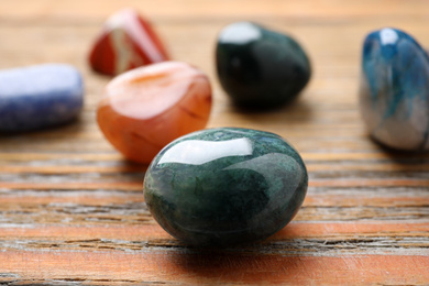 Beautiful gemstones on wooden table, closeup. Healing crystals