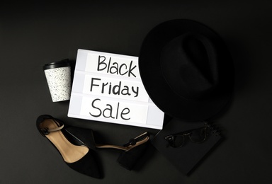 Flat lay composition with women's shoes, hat and phrase Black Friday Sale on dark background