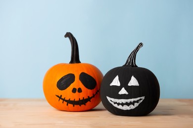 Photo of Halloween celebration. Pumpkins with spooky drawn faces on wooden table