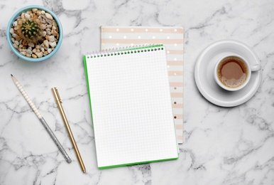 Flat lay composition with notebooks and cup of coffee on marble background