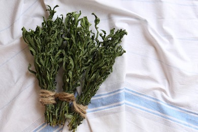 Photo of Bunches of wilted mint on white towel, flat lay. Space for text