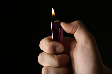 Man holding lighter on black background, closeup