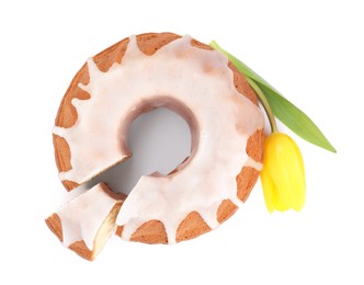Photo of Traditional Easter cake and yellow tulip on white background, top view