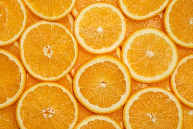 Fresh orange slices as background, top view
