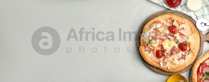 Delicious homemade pita pizza on light marble table, flat lay with space for text. Banner design