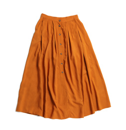 Elegant long orange skirt isolated on white, top view