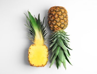 Photo of Whole and cut pineapples on white background, flat lay