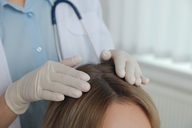 Young woman visiting trichologist in clinic, closeup