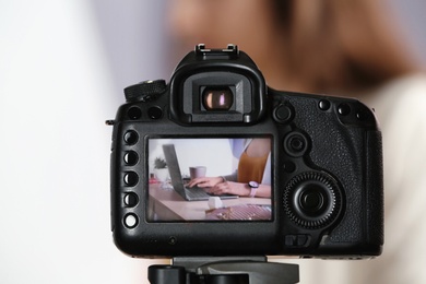 Photo of blogger at workplace on camera screen, closeup