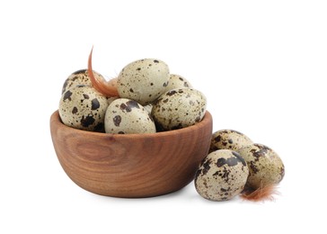 Wooden bowl, quail eggs and feathers on white background