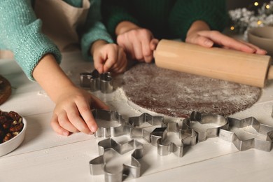 Mother and child making Christmas cookies at white wooden table together, closeup