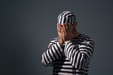 Prisoner in special uniform on dark grey background, space for text