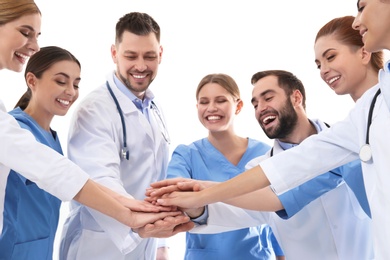 Team of medical doctors putting hands together on white background. Unity concept