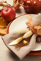Festive table setting with autumn decor on wooden background, closeup